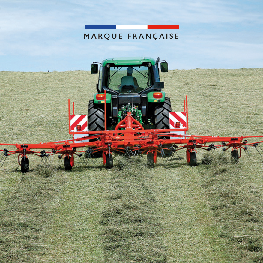 Faneuse tractée par un tracteur dans un champs